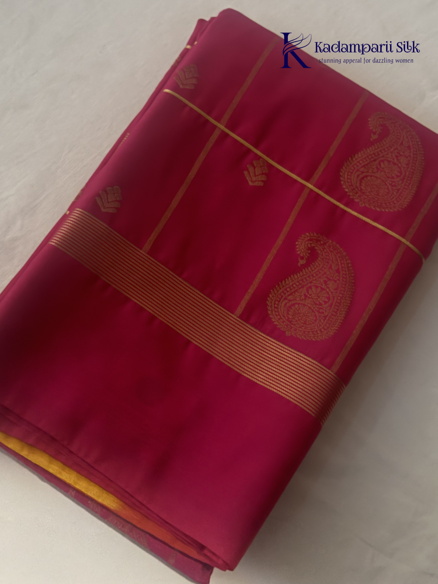 Pink art silk saree with mustard zari border and traditional gold woven motifs displayed on white background
