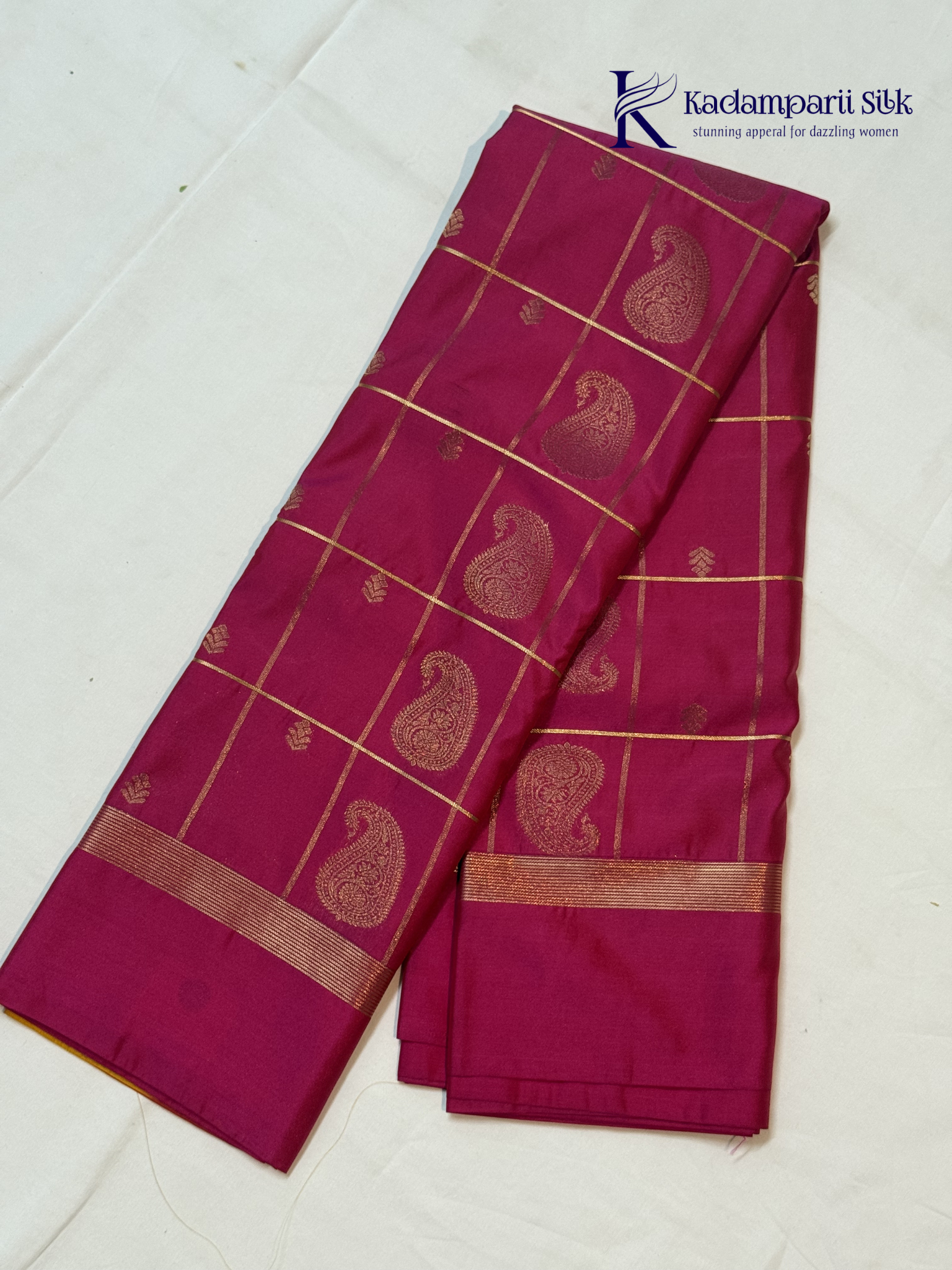 Pink art silk saree with mustard zari border and traditional gold woven motifs displayed on white background Kadamparii Silk