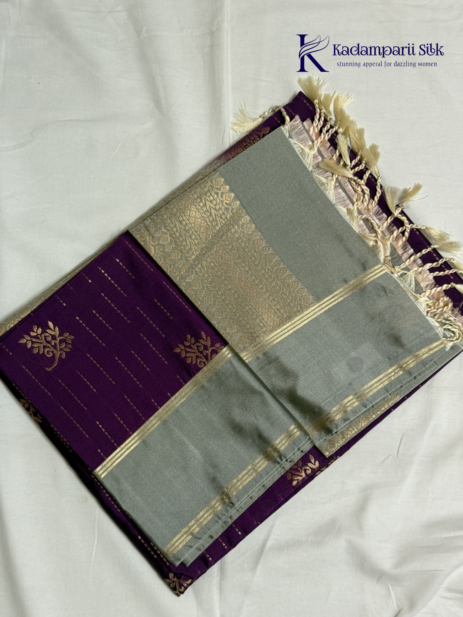 Kadamparii Silk royal purple semi soft silk saree with silver zari woven pallu, floral motifs, elegant border detailing, and tassel finish.