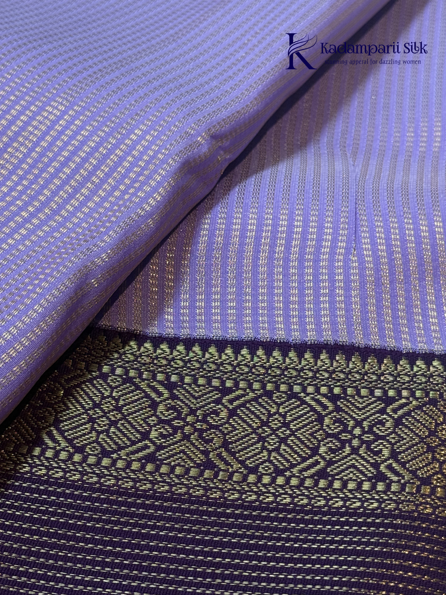Lavender art silk saree with royal purple zari woven border and gold stripe detailing displayed on white background