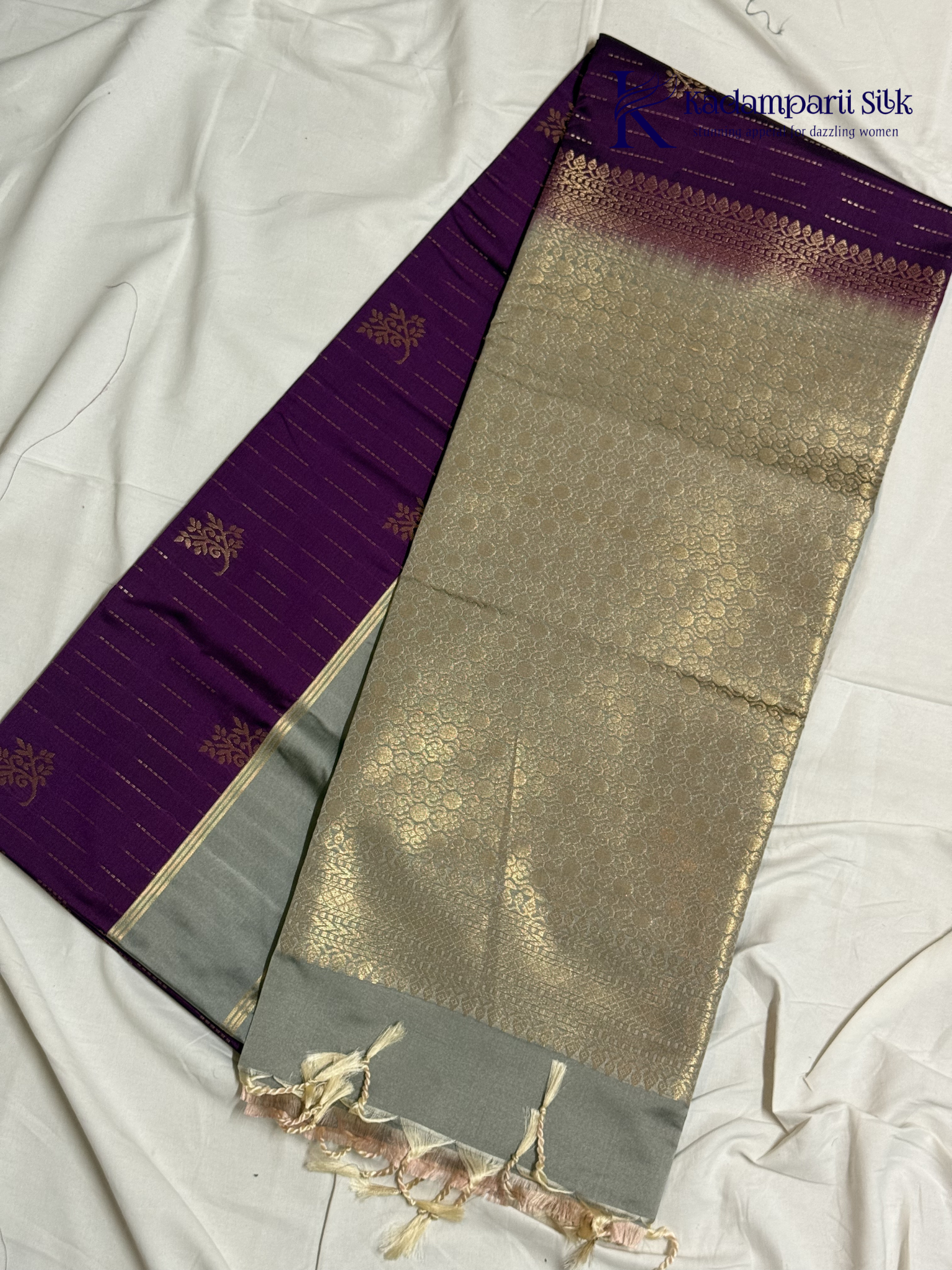 Kadamparii Silk royal purple semi soft silk saree with silver zari woven pallu, floral motifs, elegant border detailing, and tassel finish.