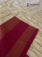 Off white art silk saree with rani pink zari border and traditional gold woven detailing displayed on white background