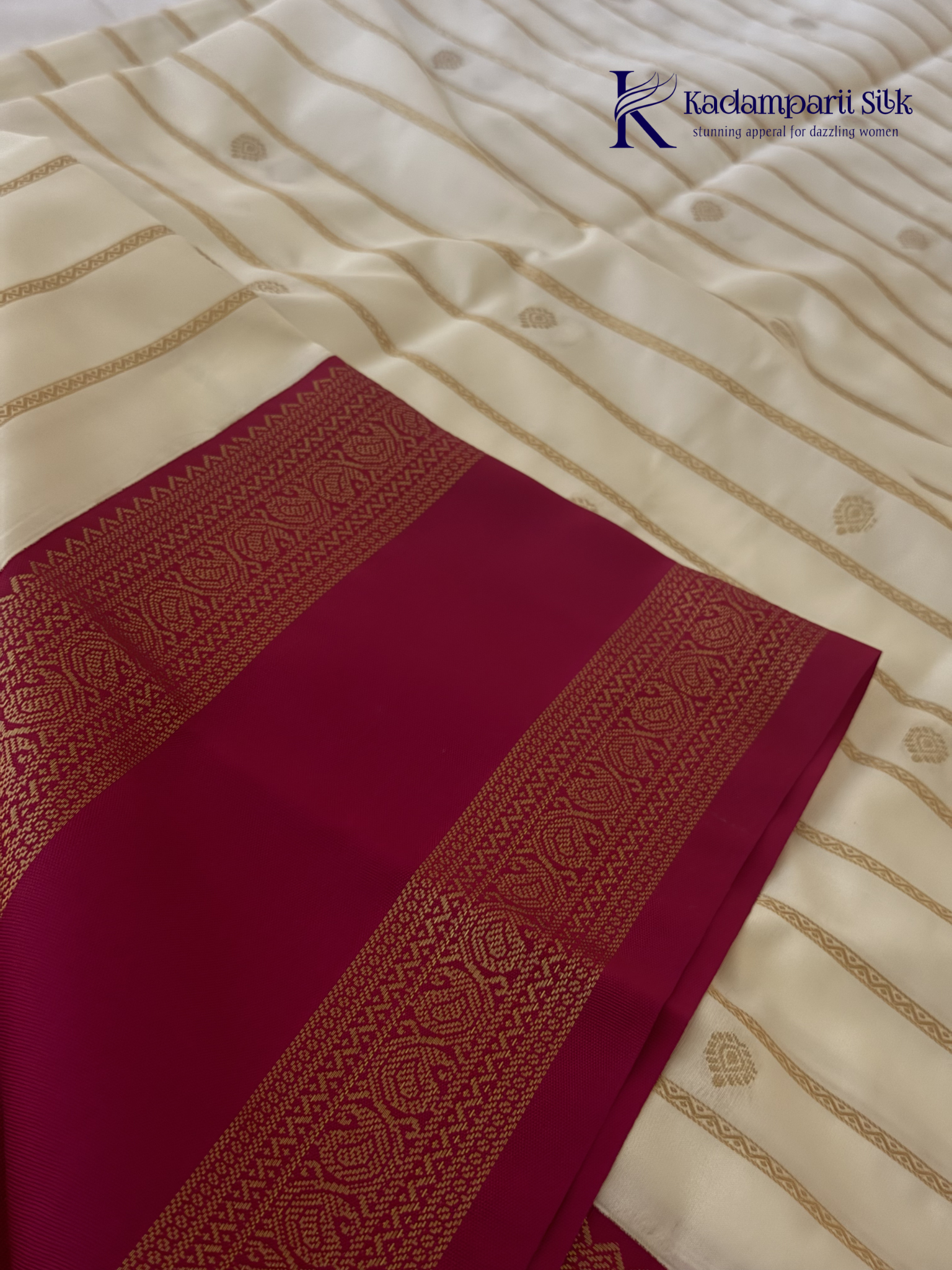 Off white art silk saree with rani pink zari border and traditional gold woven detailing displayed on white background