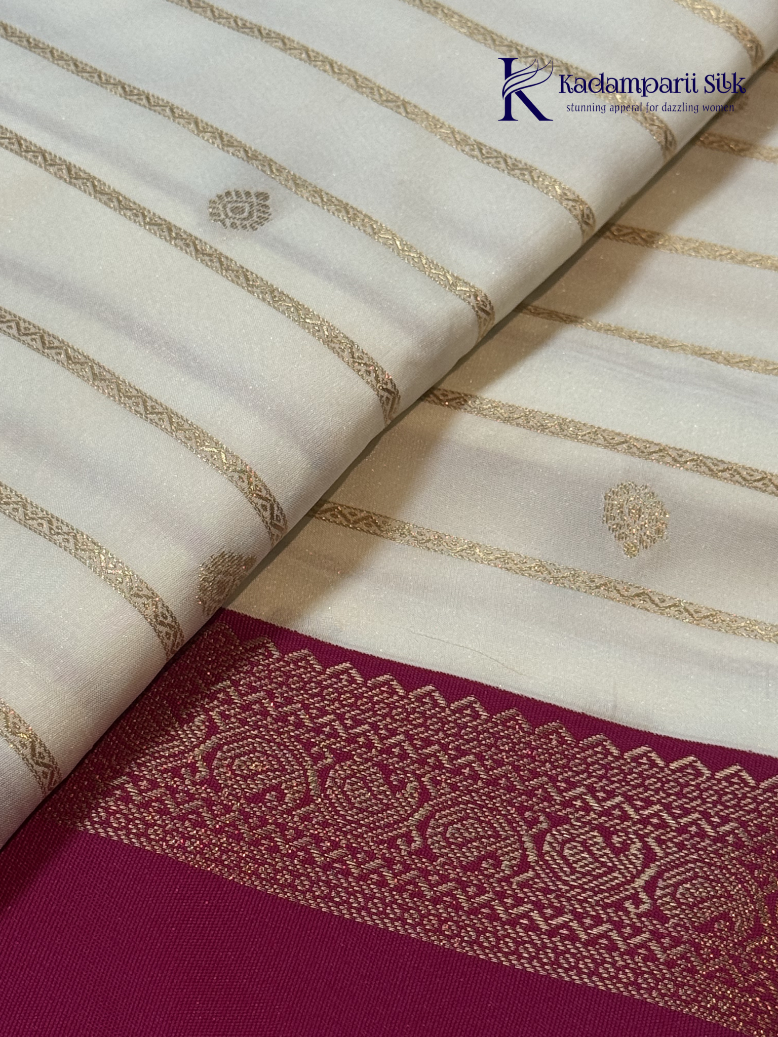 Off white art silk saree with rani pink zari border and traditional gold woven detailing displayed on white background