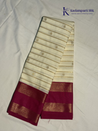 Off white art silk saree with rani pink zari border and traditional gold woven detailing displayed on white background