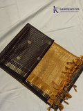 Kadamparii Silk dark chocolate semi soft silk saree with golden checked weaving, zari buttis, rich gold zari pallu, and tassel detailing.