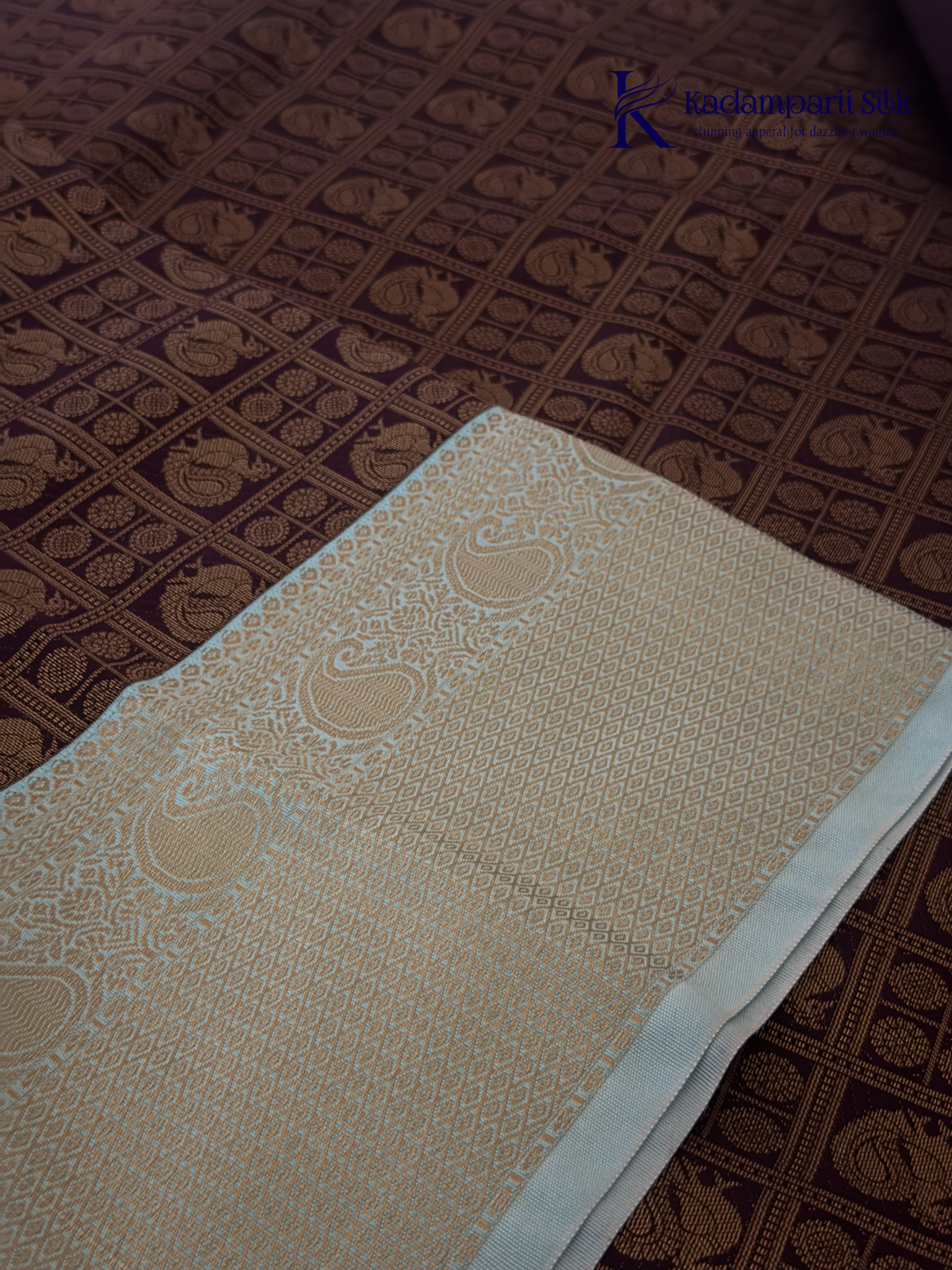 Chocolate brown art silk saree with ice blue zari woven border and traditional peacock motifs displayed on white background Kadamparii Silk