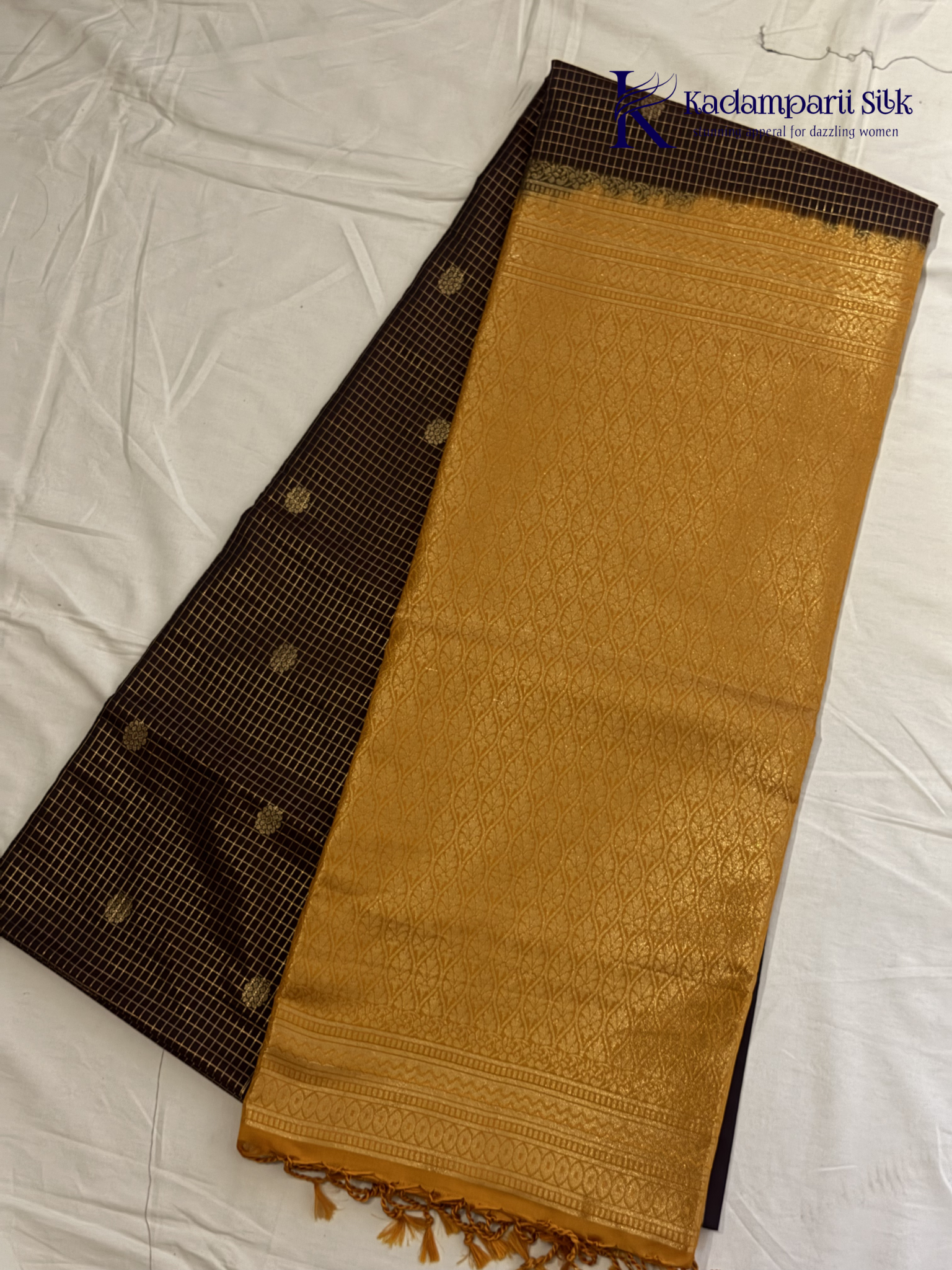Kadamparii Silk dark chocolate semi soft silk saree with golden checked weaving, zari buttis, rich gold zari pallu, and tassel detailing.