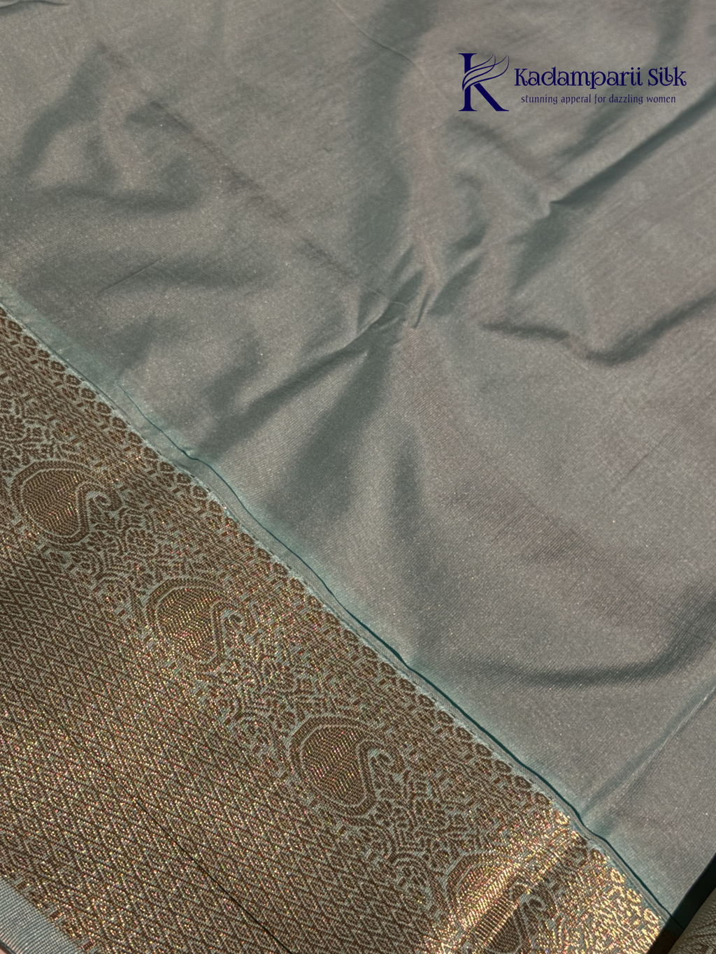 Chocolate brown art silk saree with ice blue zari woven border and traditional peacock motifs displayed on white background Kadamparii Silk