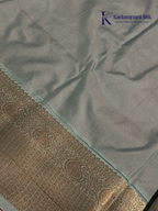 Chocolate brown art silk saree with ice blue zari woven border and traditional peacock motifs displayed on white background Kadamparii Silk