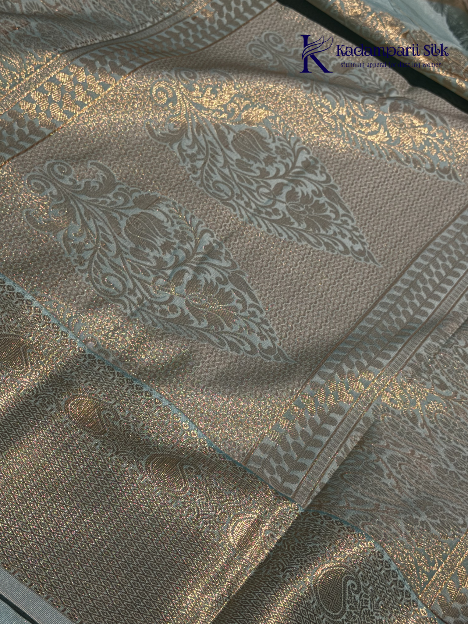 Chocolate brown art silk saree with ice blue zari woven border and traditional peacock motifs displayed on white background Kadamparii Silk