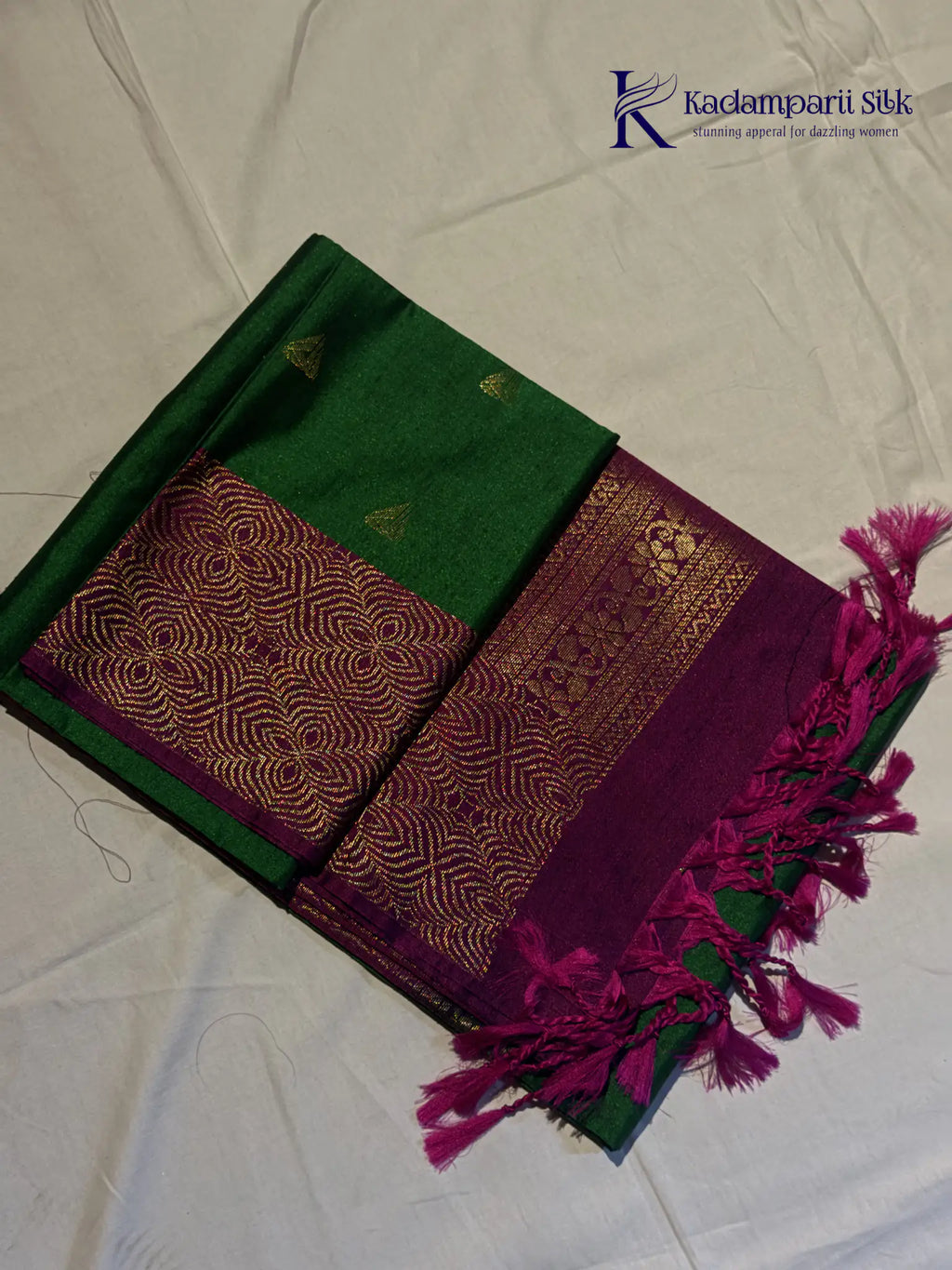 Kadamparii Silk emerald green jute mixed semi soft silk saree with magenta zari woven border, tassels, and gold zari motifs displayed on white background