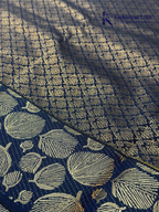 Mustard yellow art silk saree with navy blue floral zari border and textured weave displayed on white background Kadamparii SIlk