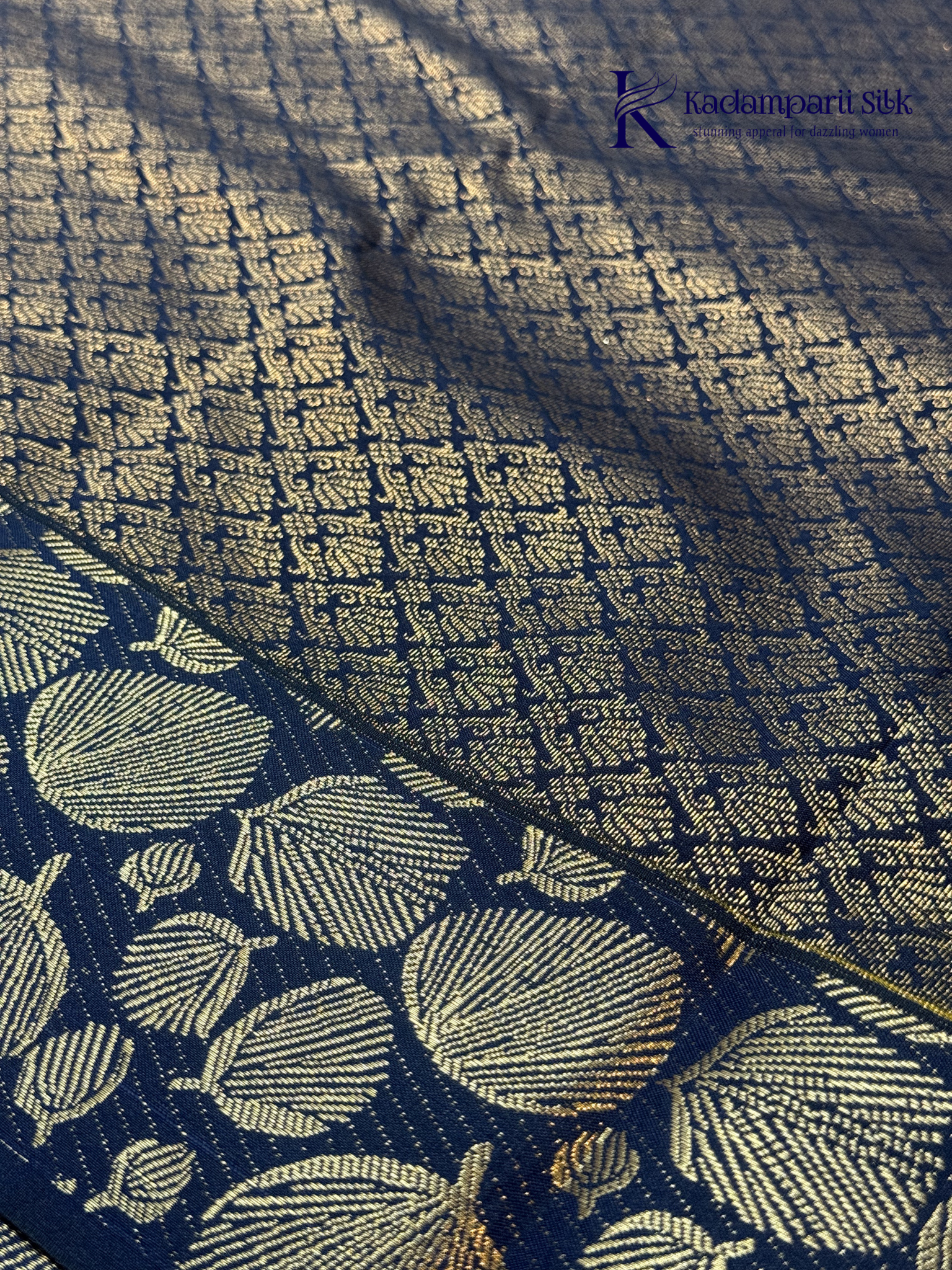 Mustard yellow art silk saree with navy blue floral zari border and textured weave displayed on white background Kadamparii SIlk