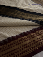 Kadamparii Silk ivory semi soft silk saree with black zari woven border and pallu, intricate traditional patterns, subtle checked texture, and tassel detailing.