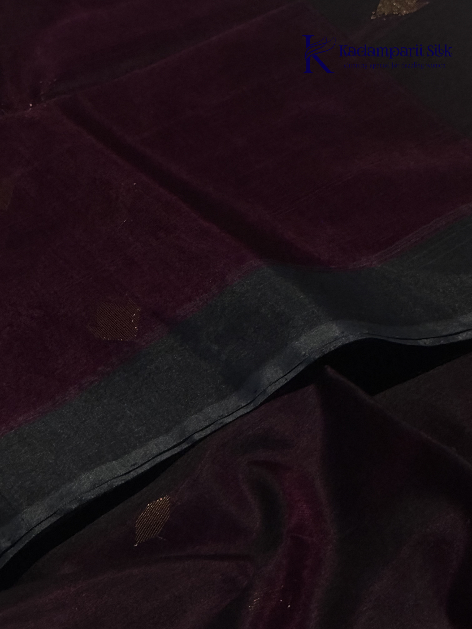Wine silk cotton saree with black zari woven pallu and gold zari detailing displayed on white background
