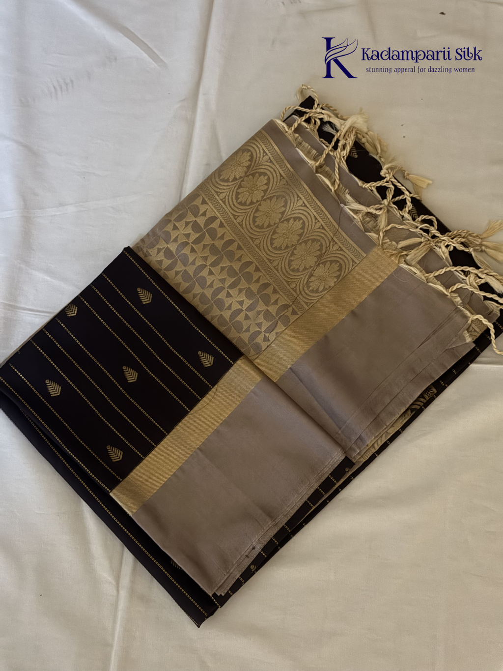 Kadamparii Silk midnight black semi soft silk saree with silver zari woven pallu, striped body design, elegant border, and tassel detailing.