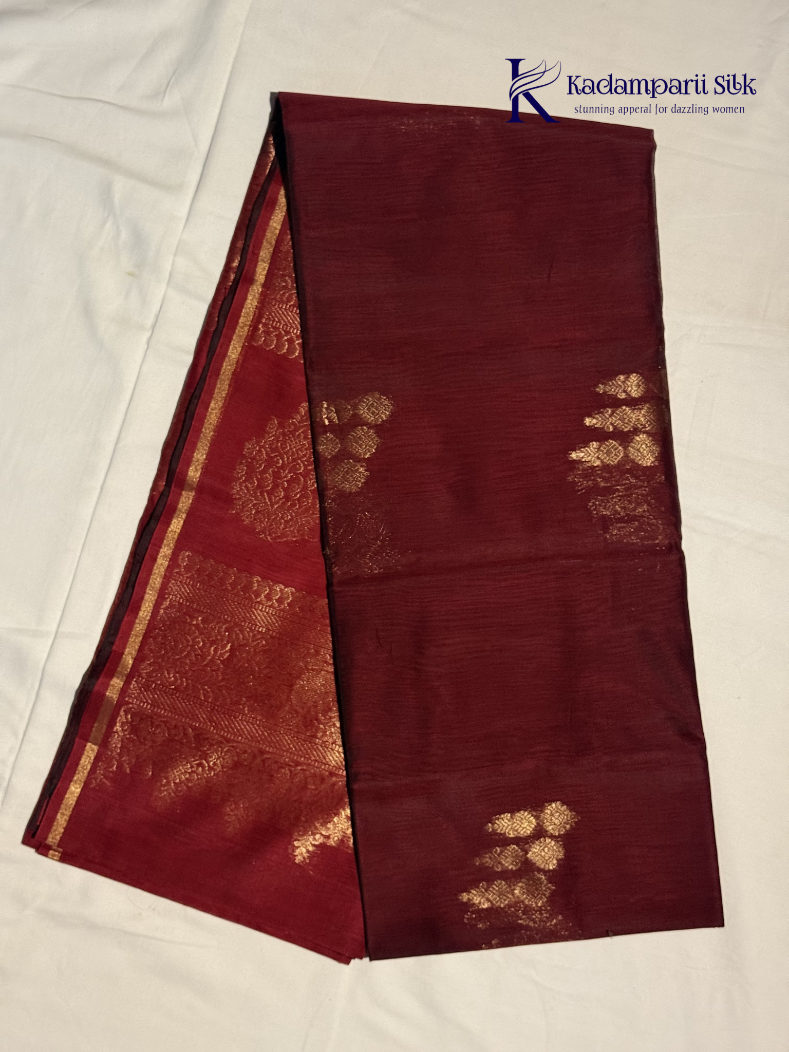Maroon saree with gold patterns on a white background, featuring the Kadambarii Silk