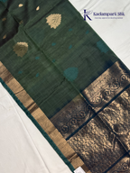 Green saree with gold and blue patterns on a white background, featuring the Kadambarii Silk brand.Silk Cotton