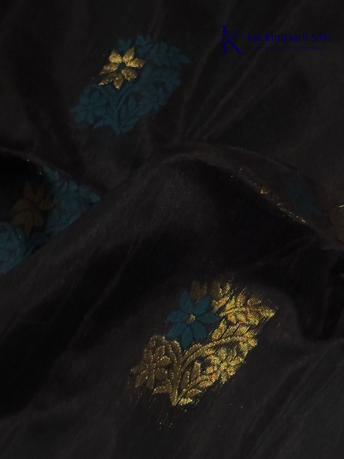 Black saree with gold and blue patterns on a white background, branded 'Kadamparii Silk'. Silk Cotton