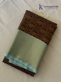 Chocolate brown art silk saree with ice blue zari woven border and traditional peacock motifs displayed on white background Kadamparii Silk